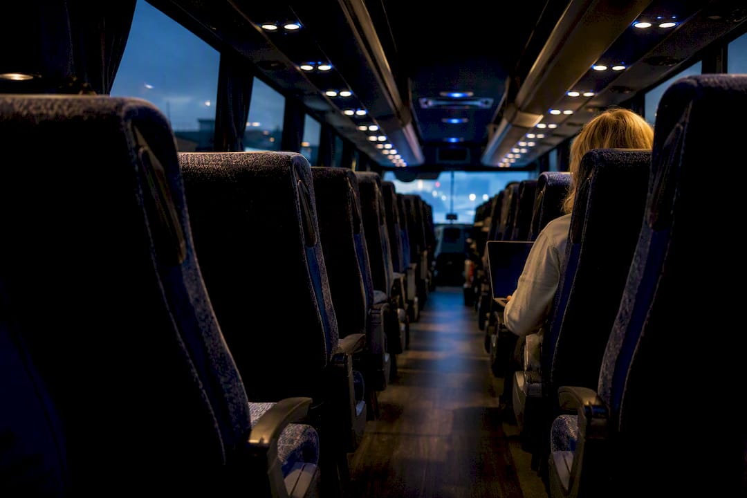 Charter bus interior with cushioned seats and armrests