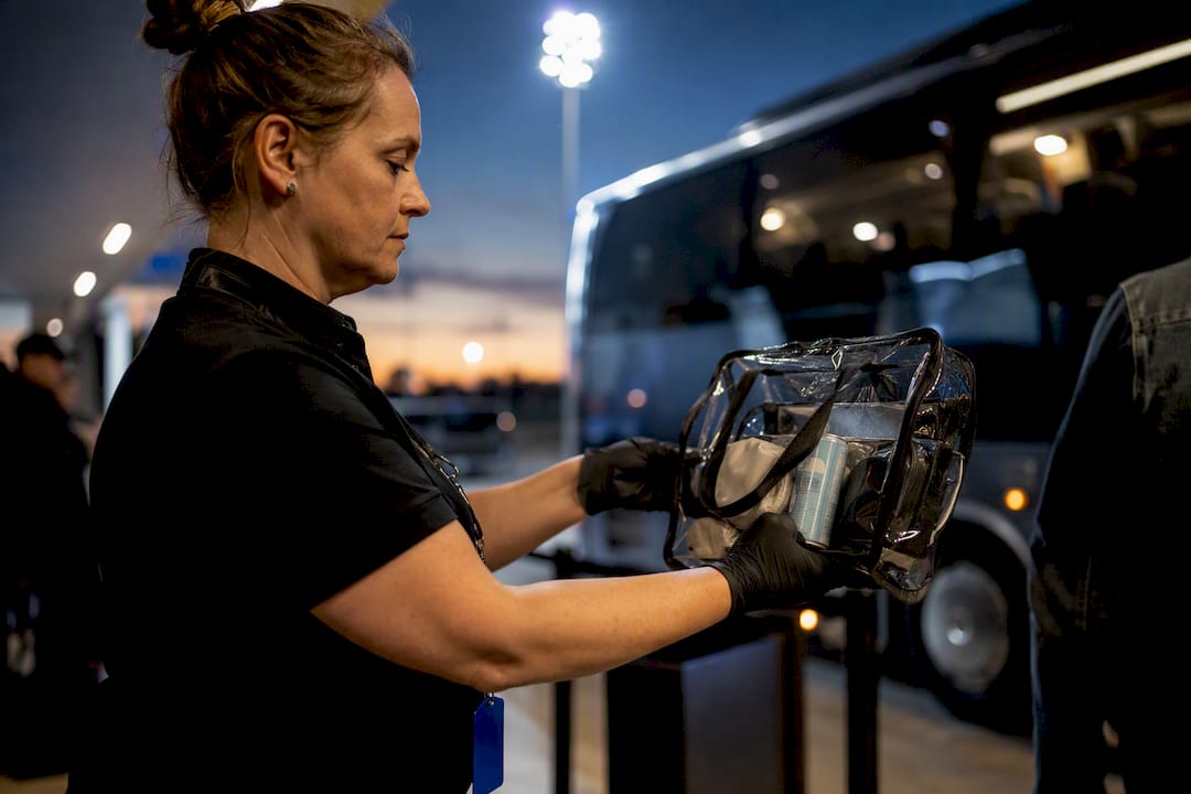Staff member checking a shuttle passenger bag