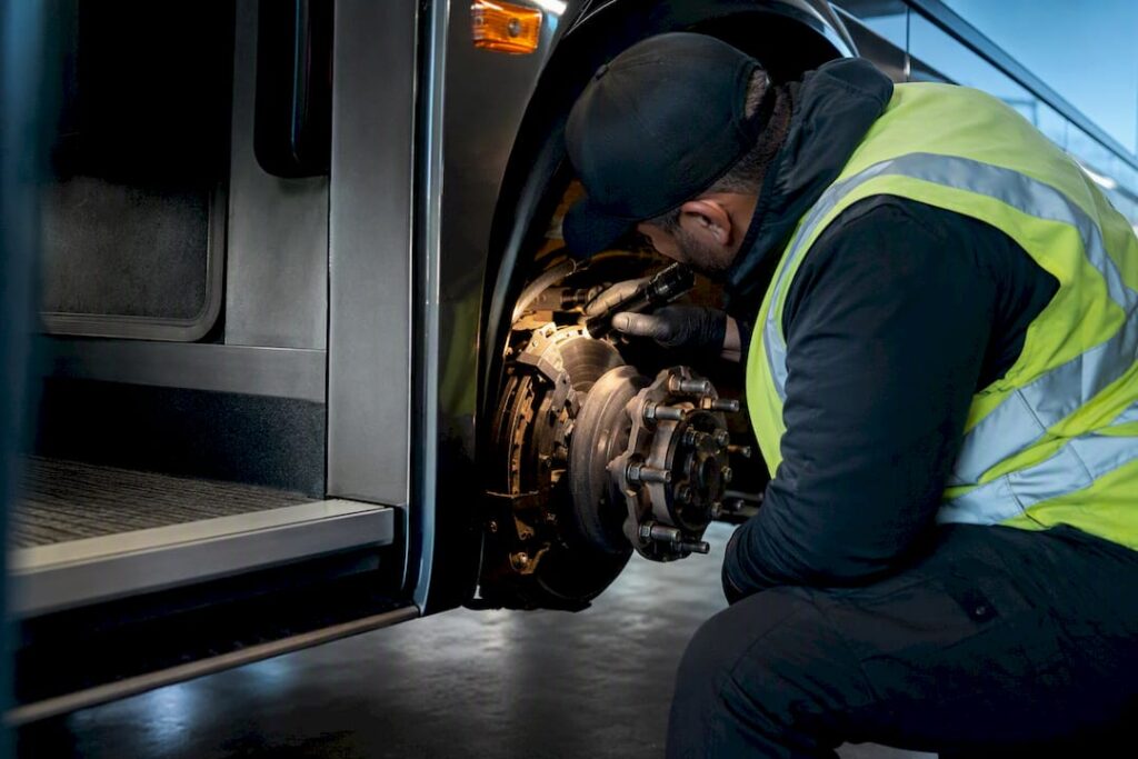 Inspector checking motorcoach wheel assembly