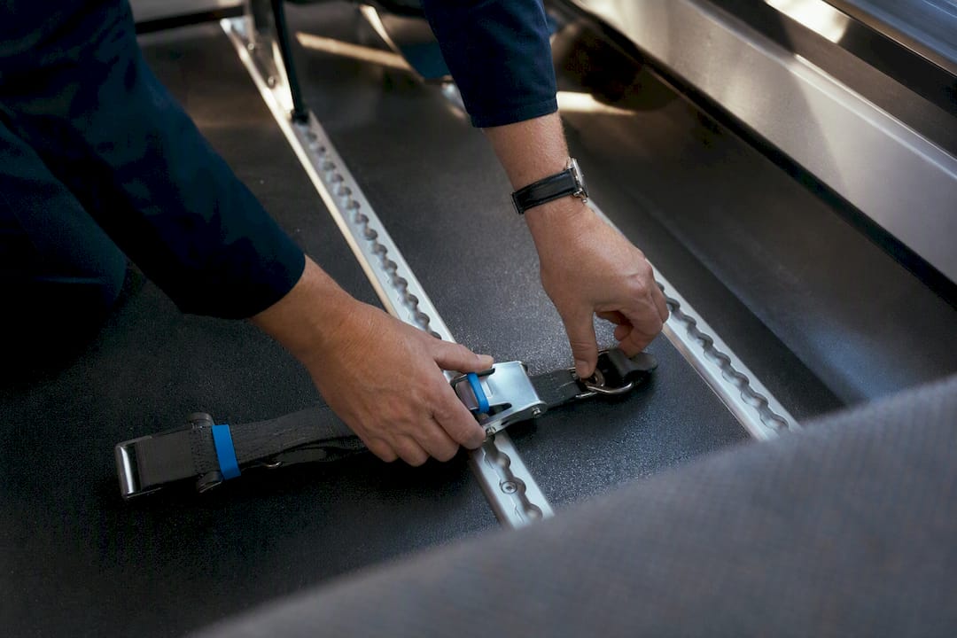Hands checking wheelchair securement straps