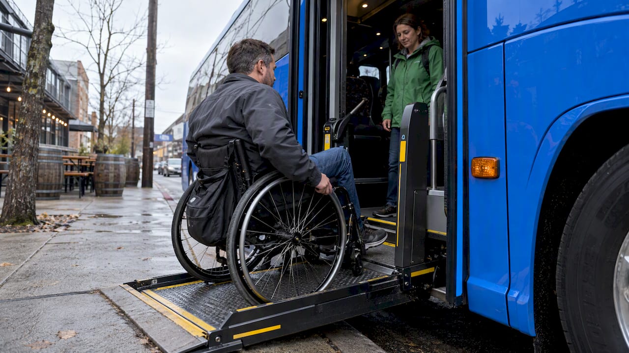 Wheelchair user boarding a charter bus lift